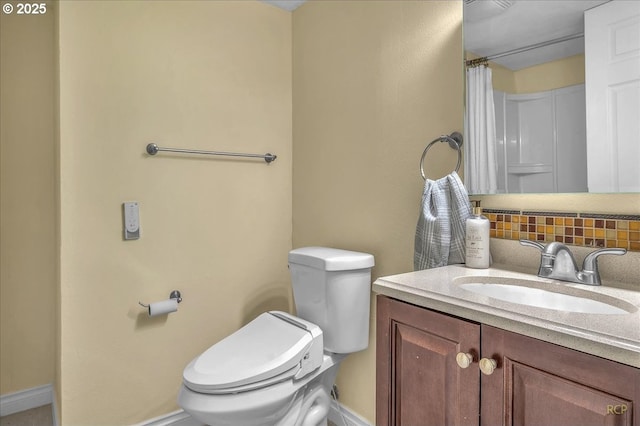 bathroom with vanity, toilet, and decorative backsplash