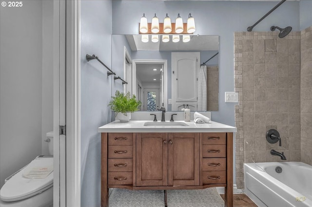 full bathroom with vanity, tiled shower / bath, and toilet