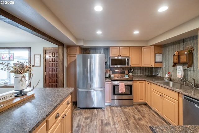 kitchen with sink, hardwood / wood-style flooring, appliances with stainless steel finishes, tasteful backsplash, and light brown cabinets