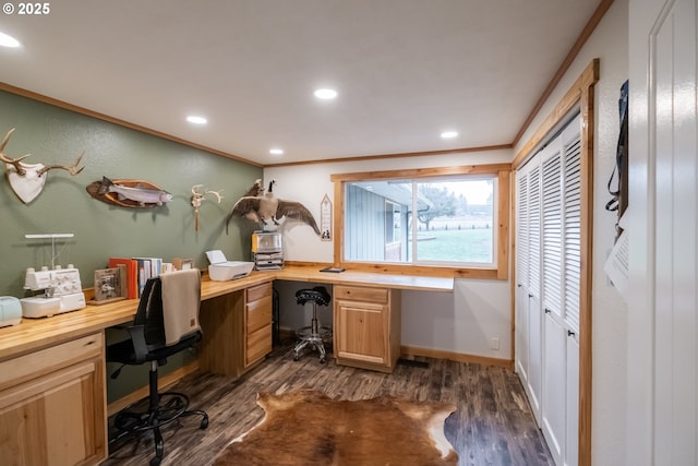 home office featuring ornamental molding, dark hardwood / wood-style flooring, and built in desk