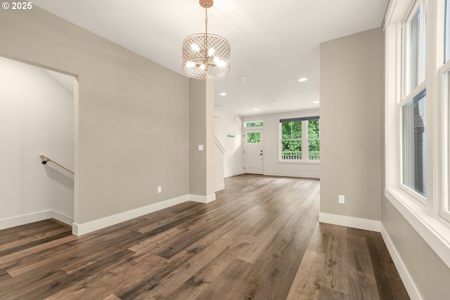 spare room featuring dark wood finished floors, a chandelier, recessed lighting, and baseboards
