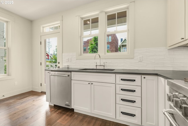 kitchen featuring a sink, appliances with stainless steel finishes, dark countertops, and decorative backsplash