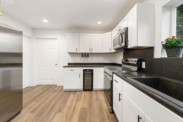 kitchen with white cabinets, appliances with stainless steel finishes, and wine cooler