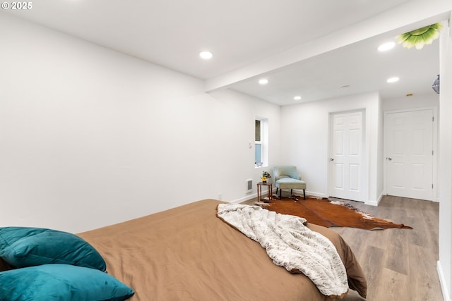 bedroom with hardwood / wood-style flooring and beamed ceiling