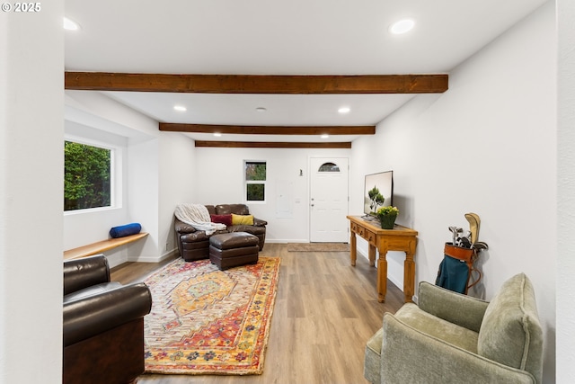 living room featuring beamed ceiling and light wood-type flooring