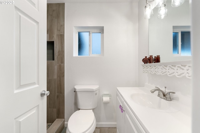 bathroom featuring walk in shower, vanity, and toilet