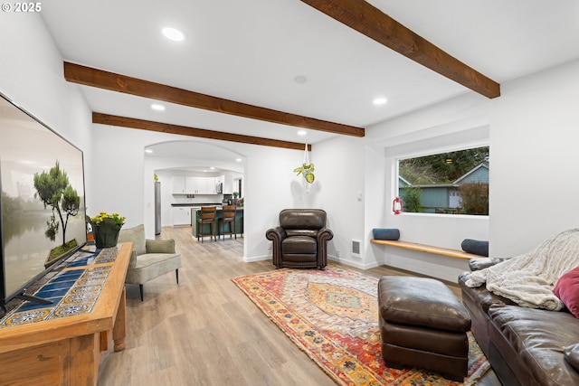 living room with beamed ceiling and light hardwood / wood-style floors