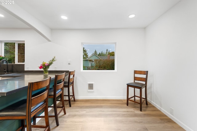 dining space featuring plenty of natural light, sink, and light wood-type flooring