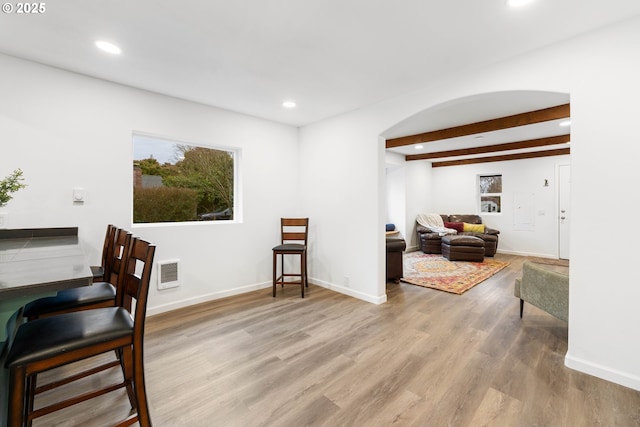 dining room with beam ceiling and light hardwood / wood-style flooring