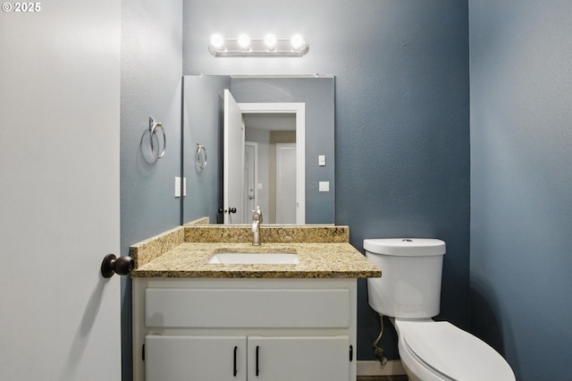 half bathroom with toilet and vanity