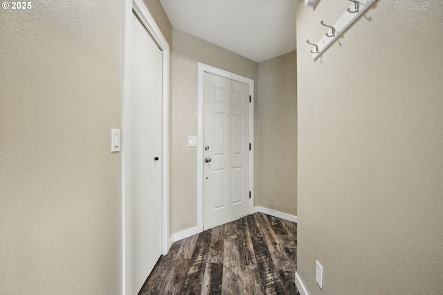 hall featuring baseboards and dark wood-style floors