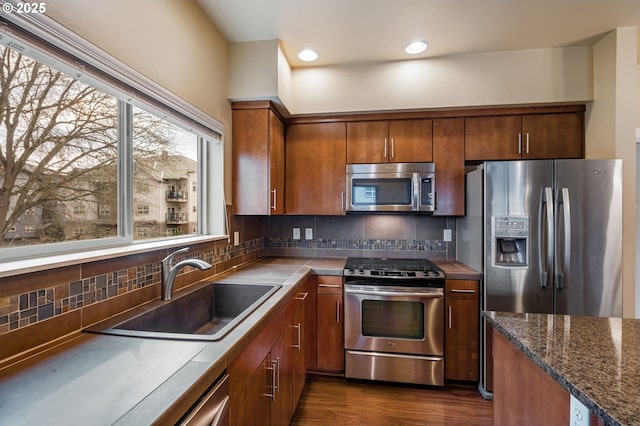 kitchen featuring appliances with stainless steel finishes, backsplash, dark hardwood / wood-style flooring, and sink