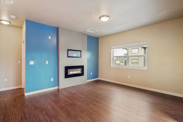 unfurnished living room with a fireplace and dark hardwood / wood-style flooring