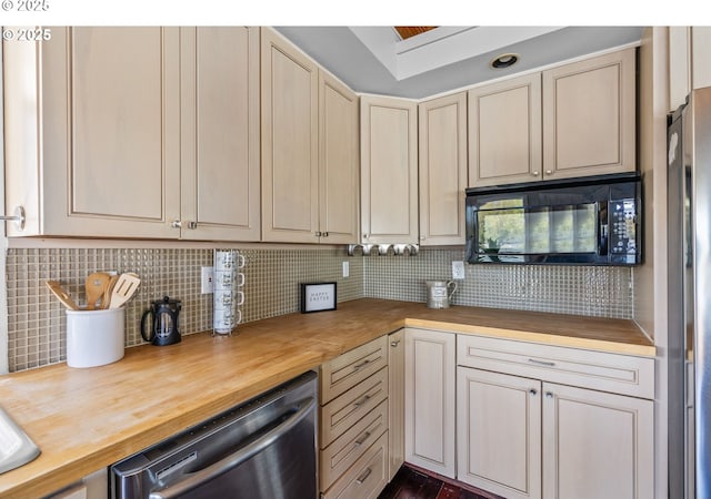 7720 SW Macadam Ave Unit 9, Portland, OR 97219 - kitchen with butcher block counters, black microwave, dishwasher, tasteful backsplash, and cream cabinetry