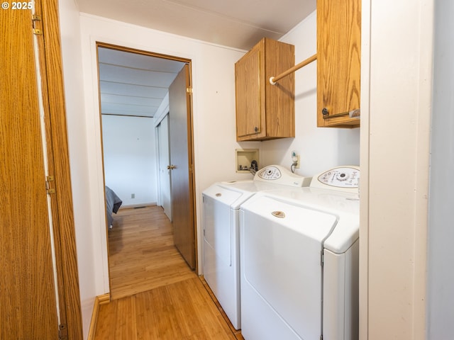 1629 N Siano Loop, Florence, OR 97439 - laundry area with washer and clothes dryer, cabinet space, and light wood-style floors