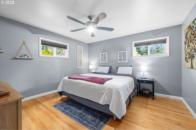 92757 Claremont Rd, Astoria, OR 97103 - bedroom featuring light wood-style floors, multiple windows, baseboards, and a ceiling fan