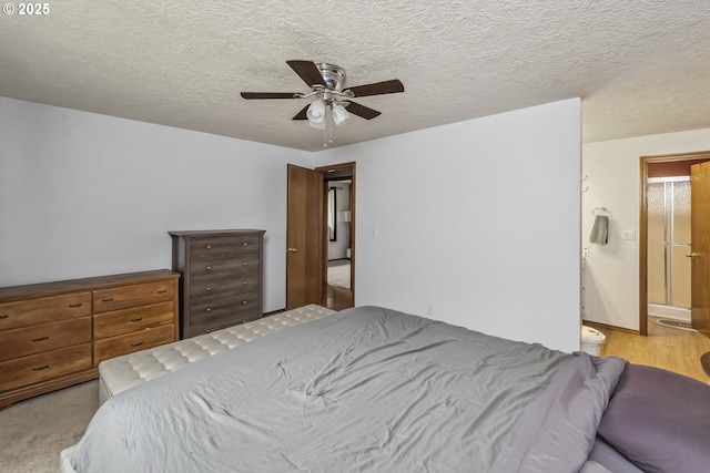 bedroom with connected bathroom, ceiling fan, and a textured ceiling