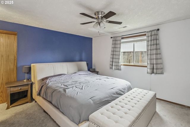 bedroom featuring ceiling fan, a textured ceiling, light carpet, visible vents, and baseboards