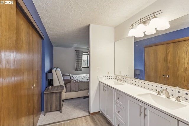 bathroom featuring decorative backsplash, connected bathroom, a sink, and double vanity