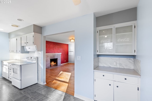 kitchen featuring white cabinetry, dark tile patterned flooring, a fireplace, and white electric stove