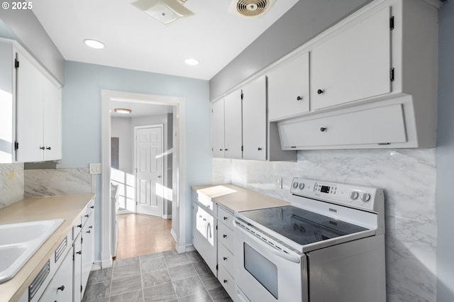 kitchen with white cabinetry, sink, white electric range, and light tile patterned floors