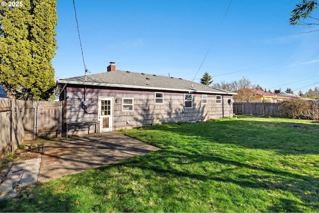 rear view of property featuring a lawn