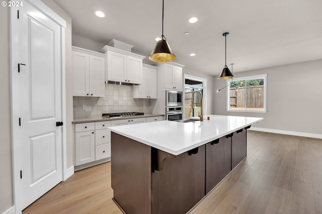 kitchen with stainless steel appliances, white cabinets, a sink, and tasteful backsplash