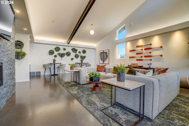 living area featuring concrete floors, high vaulted ceiling, and a stone fireplace