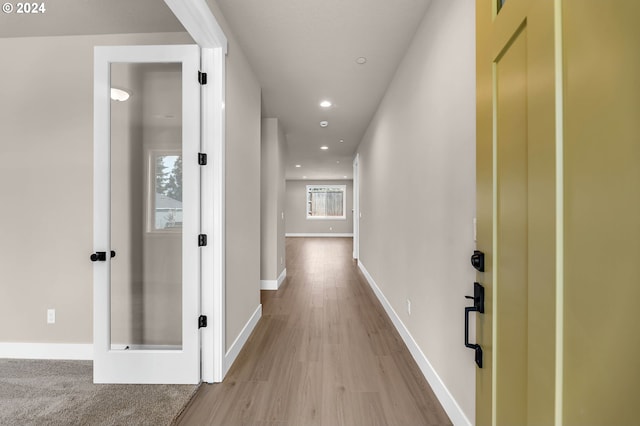 corridor featuring baseboards, wood finished floors, and recessed lighting