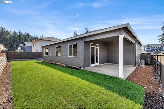 back of house with a yard, a patio area, and a fenced backyard