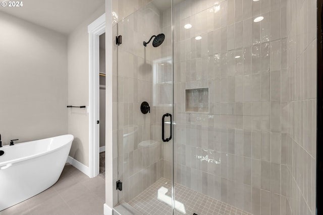 bathroom featuring tile patterned flooring, a shower stall, and a freestanding bath