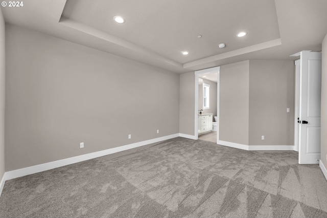 unfurnished bedroom with baseboards, a raised ceiling, carpet flooring, and recessed lighting