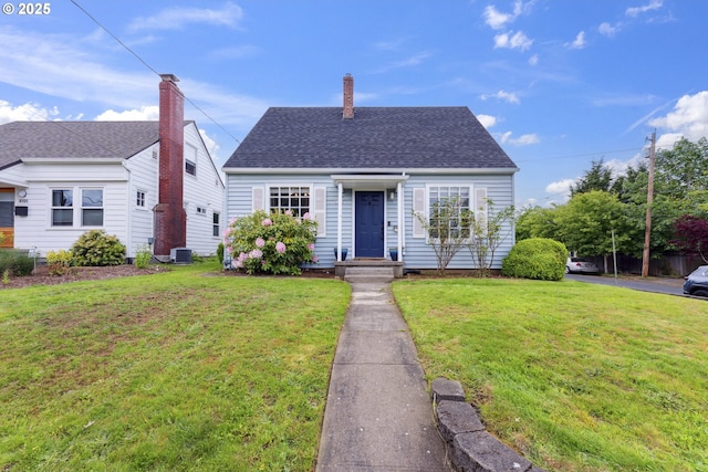 view of front of home with a front yard, central AC, a shingled roof, and a chimney