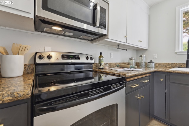 kitchen featuring stainless steel appliances, gray cabinetry, white cabinets, and dark countertops