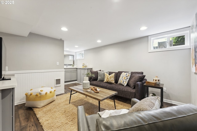 living area featuring dark wood-style floors, recessed lighting, and a wainscoted wall