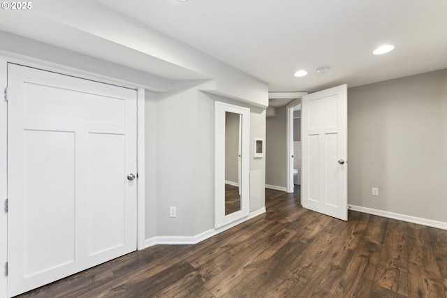 basement featuring recessed lighting, dark wood-style flooring, and baseboards