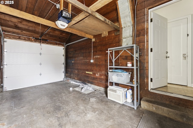 garage with wood walls, a garage door opener, and wood ceiling