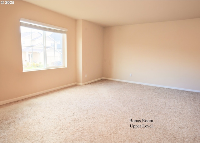 empty room with baseboards and carpet