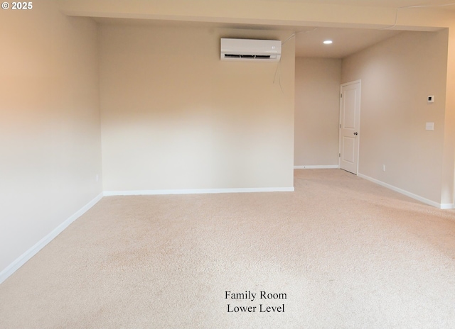 empty room with recessed lighting, baseboards, a wall mounted air conditioner, and light carpet