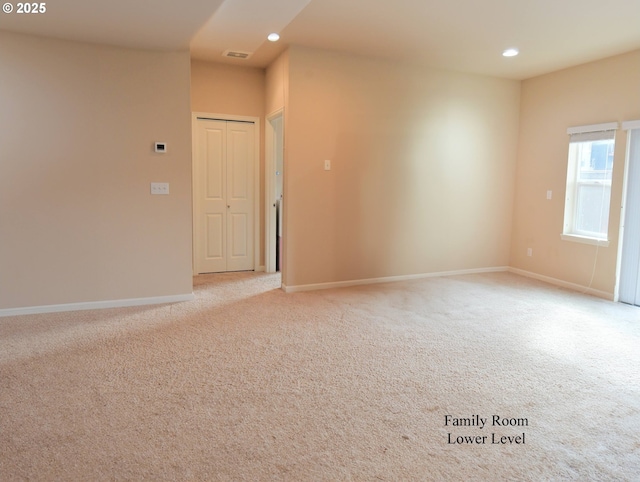 empty room featuring recessed lighting, baseboards, light carpet, and visible vents