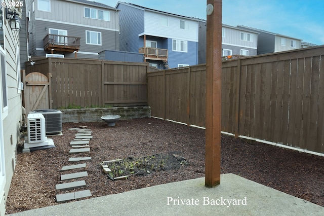 view of yard with central air condition unit, a fenced backyard, and a residential view