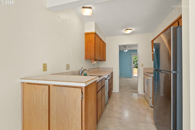 5312 SW Erickson Ave, Beaverton, OR 97005 - kitchen featuring appliances with stainless steel finishes, light countertops, ceiling fan, a textured ceiling, and a peninsula