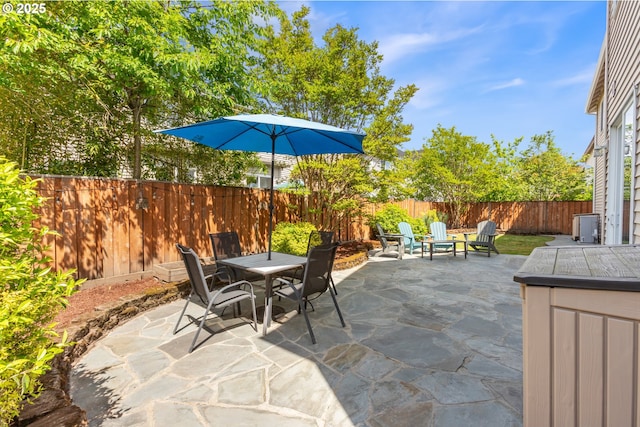 view of patio featuring outdoor dining space, a fenced backyard, and an outdoor fire pit