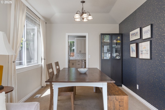 dining room with wallpapered walls, a chandelier, healthy amount of natural light, carpet, and baseboards
