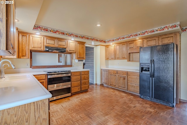 kitchen with sink, black fridge, stainless steel range with electric cooktop, and light parquet flooring