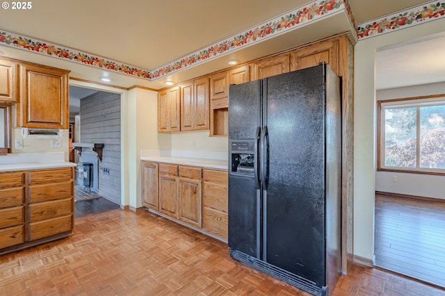 kitchen featuring black fridge with ice dispenser and light parquet flooring