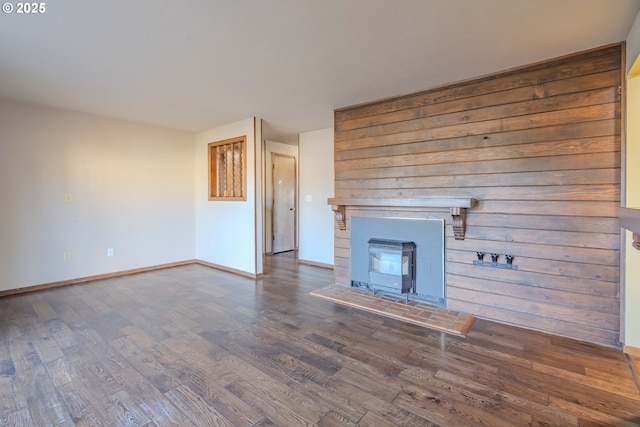 unfurnished living room featuring dark hardwood / wood-style flooring and a wood stove