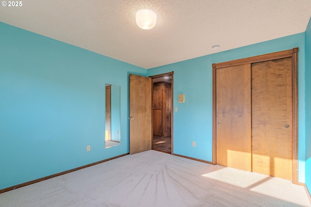 unfurnished bedroom featuring a textured ceiling, carpet floors, and a closet