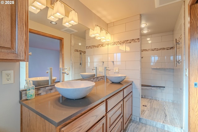 bathroom with a shower, vanity, and tasteful backsplash