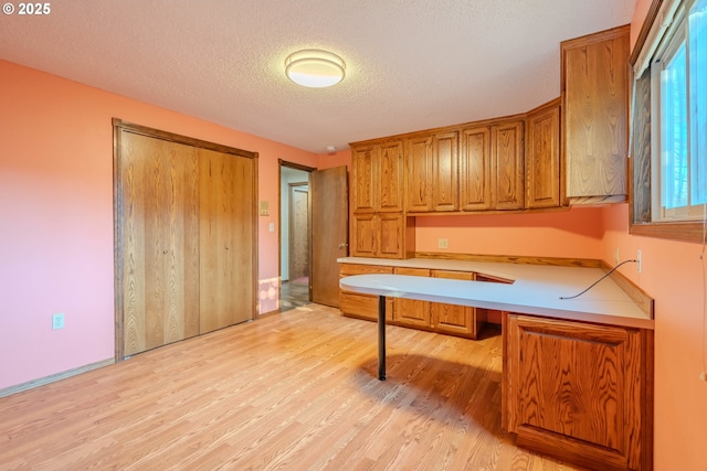 kitchen featuring a textured ceiling and light hardwood / wood-style flooring